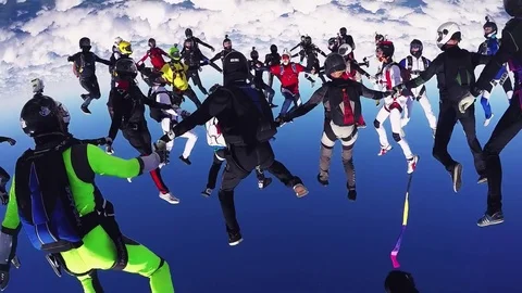 Professional skydivers parachuting, make formation in air in sunny day. Blue sky Stockbeeldmateriaal 70532638