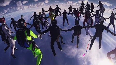 Professional skydivers parachuting, make formation in air in sunny day. Extreme Видео 70532873