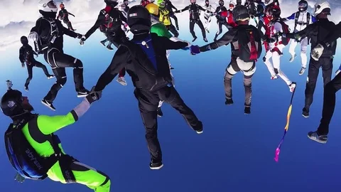 Professional skydivers parachuting, make formation in air in sunny day. Stunt Stockbeeldmateriaal 70533061