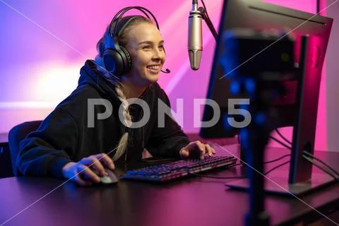 Professional smiling esport gamer girl live streaming and plays online video Stock Photos