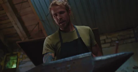 Professional smith is processing metal detail on anvil, use large hammer Stock Footage 205157212