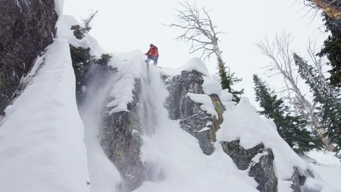 Professional snowboarder performing jump down snow covered mountain Видео 116745205