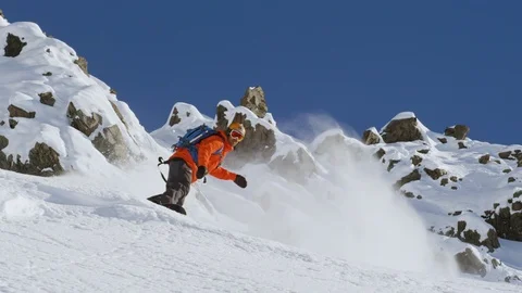 Professional snowboarder shredding down snow covered mountain slope Stock Footage 116749250