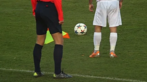 Professional soccer player kicking ball to score goal, referee watching game Stock Footage