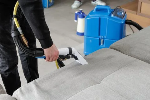 Professional sofa cleaning service using extraction machine on fabric uphol.. Stock Photos