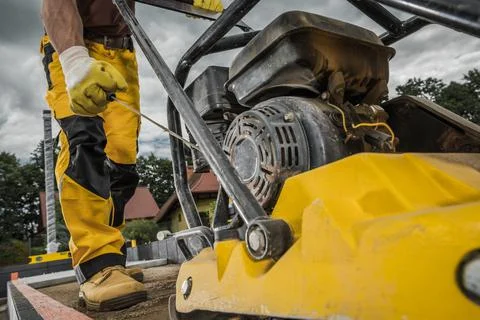 Professional Soil Compactor Operated by Construction Worker Foto stock