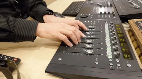 Professional sound engineer adjusting audio faders on mixing console at rec.. Stock Footage 337806648