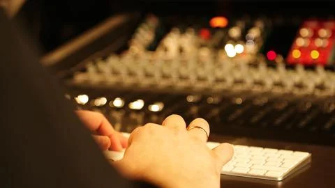 Professional Sound Engineer Operating Audio Mixer And Computer In Studio Stockfoto's