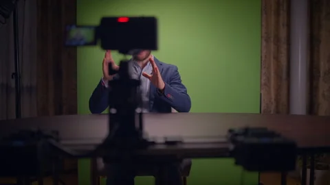 A Professional Speaker is ready on a Green Screen Set for effective Video stock 294647913