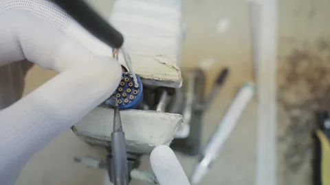 Professional in a sterile environment carefully uses precise soldering tools  Stockbeeldmateriaal 331891535