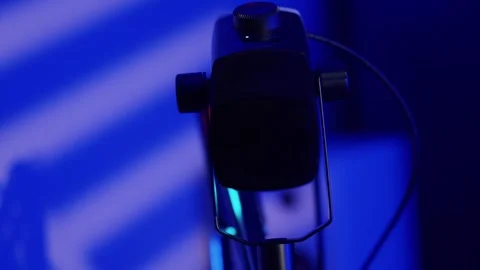 Professional studio microphone in a dark room with vibrant RGB lighting setup Stock Footage 346774209