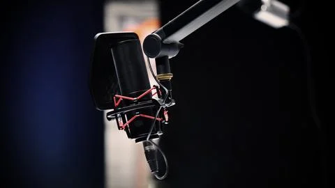 Professional studio microphone with a pop filter is suspended boom arm and .. Stock Photos