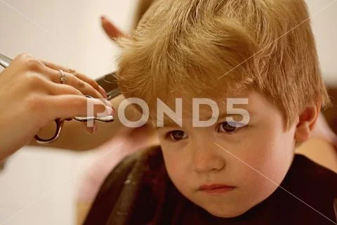 Professional styling. Cute boys hairstyle. Little child given haircut. Small Stock Photos