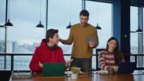 Professional supervisor explaining project to two managers at laptops in office. Stock Footage 340073368