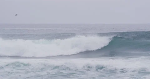 Professional surfer catching ocean wave and riding it down during cloudy day Stock Footage 156010877