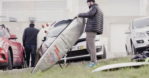 Professional surfers preparing their equipment for surfing in parking lot Stock Footage 164309541