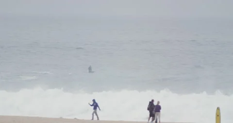 Professional surfers riding huge waves on surfboards and jet skis in ocean Stock Footage 155607117