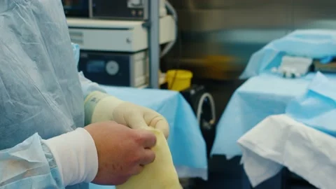 Professional surgeon putting on protective gloves in operating room 스톡 동영상 229643017
