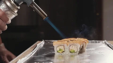 Professional sushi chef preparing roll via fire at commercial kitchen, close-up. Stock Footage 82750121