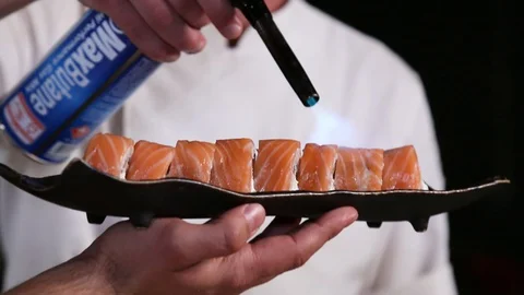 Professional sushi chef preparing roll via fire from gas burner Stock Footage 129832060