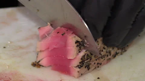 Professional Sushi chef slices seared Ahi tuna at sushi bar Stock Footage 167144035