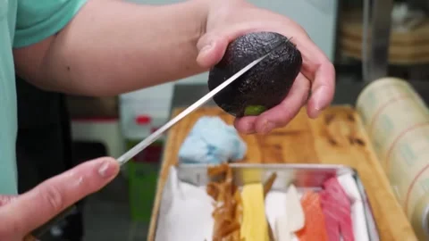 Professional Sushi Chef Slicing Fresh Avocado for Sashimi Platter Stock Footage 333526337