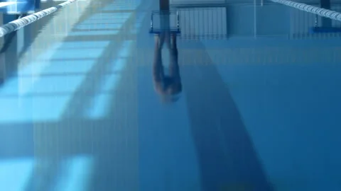 A professional swimmer dives into the pool, picking up a lot of splashes Video stock 119499508