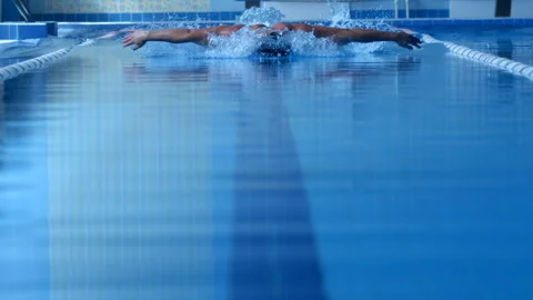A professional swimmer dives into the pool, picking up a lot of splashes Stock Footage 119499597