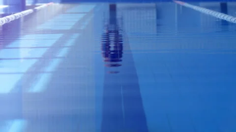 A professional swimmer dives into the pool, picking up a lot of splashes Stock Footage 119499650