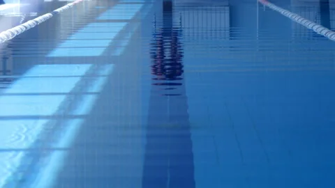 A professional swimmer dives into the pool, picking up a lot of splashes Stock Footage 119499836