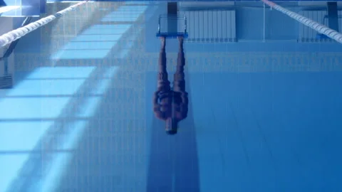A professional swimmer dives into the pool, picking up a lot of splashes Stock Footage 119499888