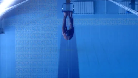 A professional swimmer dives into the pool, picking up a lot of splashes Stock Footage 119499908