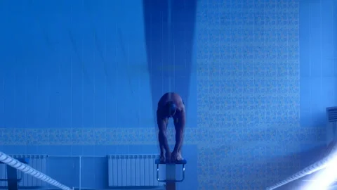A professional swimmer dives into the pool, picking up a lot of splashes Stock Footage 119500697