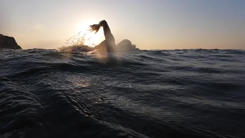 Professional swimmer at open sea. Epic sunset swim slow motion shot Stock Footage 159792724