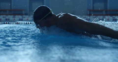 A professional swimmer raising a lot of splashes is swimming in butterfly style  Stock Footage