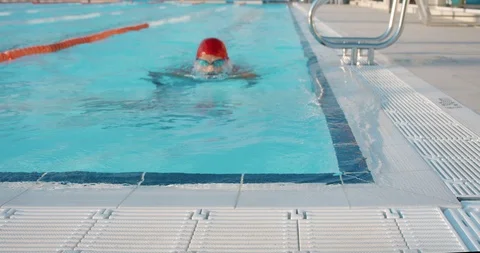 Professional swimmer in red cap and goggles finishing his morning training in Stock-Footage 120300924