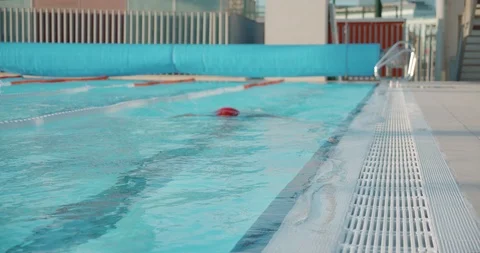 Professional swimmer in red cap and goggles performing breaststroke during 動画素材 120300963