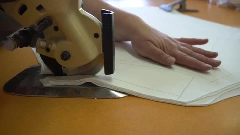 Professional tailor cuts fabric with round cutting machine Stock Footage 136400539