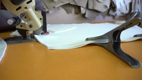 Professional tailor cuts white fabric with rotary cutter Stock Footage 136400558