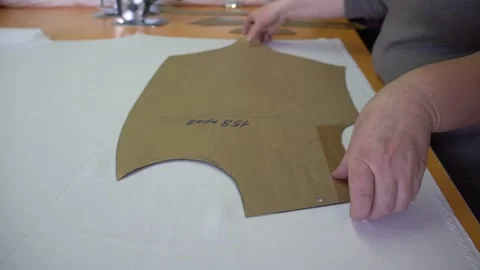 Professional tailor hands take paper template from fabric Stock Footage 136400562