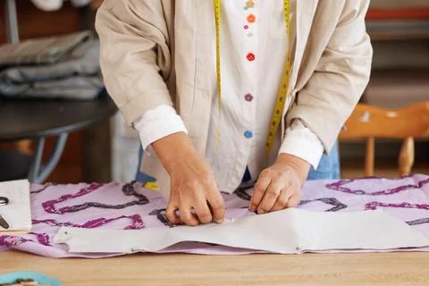 Professional Tailor Pinning Paper Pattern Onto Violet Fabric In Creative Wo.. Stock Photos