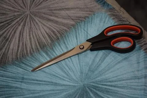 Professional Tailor Scissors Resting on Patterned Blue and Gray Fabric Foto stock