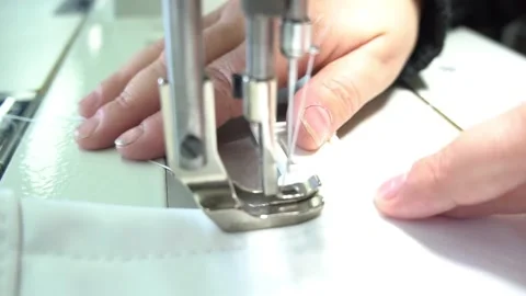 Professional tailor sews white fabric with electric machine Stock Footage 136400549