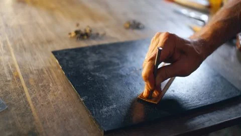 Professional tanner working with leather. Stock Photos