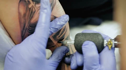 Professional tattoo master draws on man's shoulder. Stock Footage 61353445