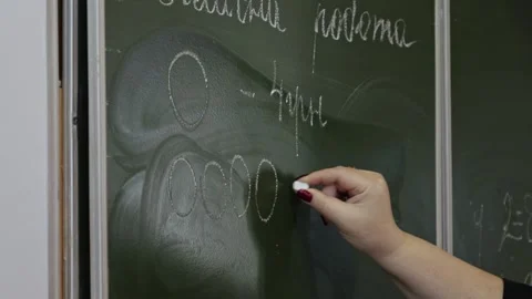 A professional teacher writes complex math exercises on a green chalkboard .. Stock Footage 339861135