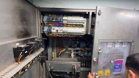 Professional technician checking industrial electrical control cabinet wiring Stock Footage 329608080