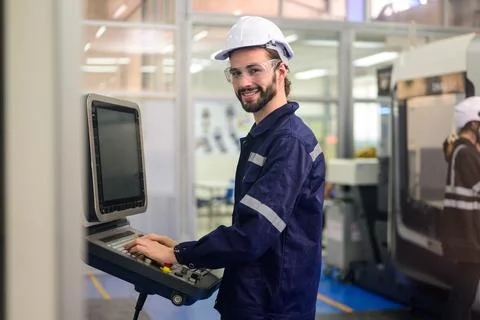 Professional technician checking part of automatic machine at factory Stock Photos