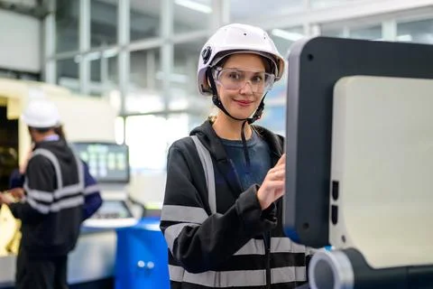 Professional technician checking part of automatic machine at factory Stock Photos