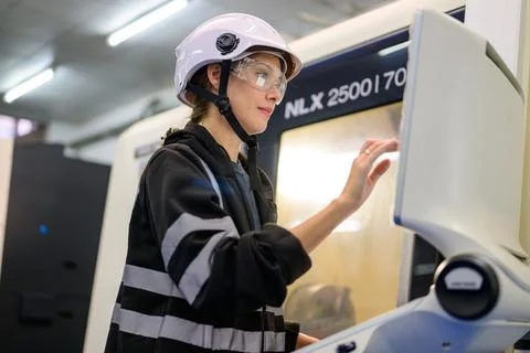 Professional technician checking part of automatic machine at factory Stock-Fotos